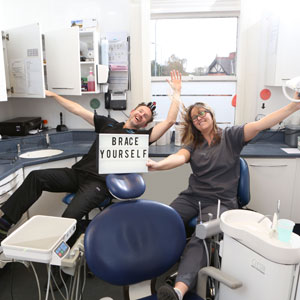 Dentist team with ‘Brace Yourself’ sign