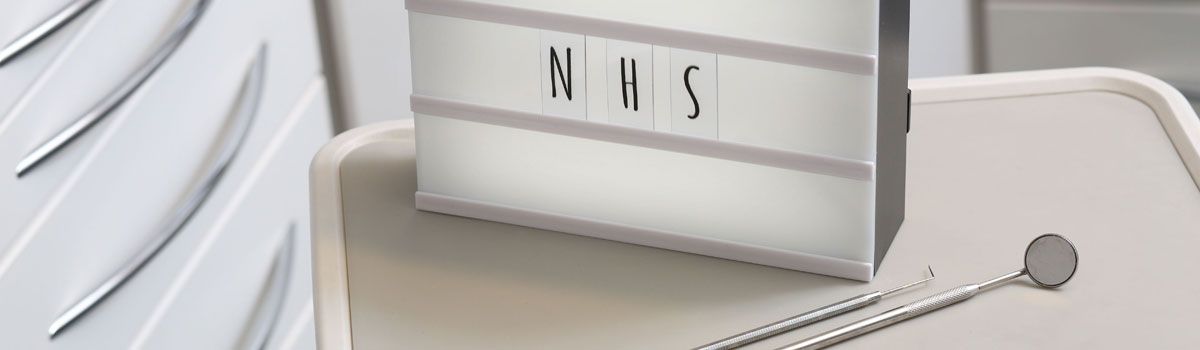 ‘NHS’ on illuminated board in dental treatment room