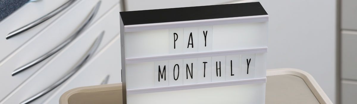 ‘Pay Monthly’ on illuminated board in dental treatment room