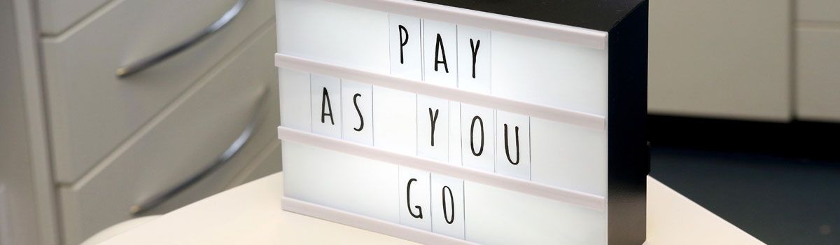 ‘Pay As You Go’ on illuminated board in dental treatment room