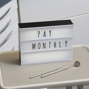 ‘Pay Monthly’ on illuminated board in dental treatment room